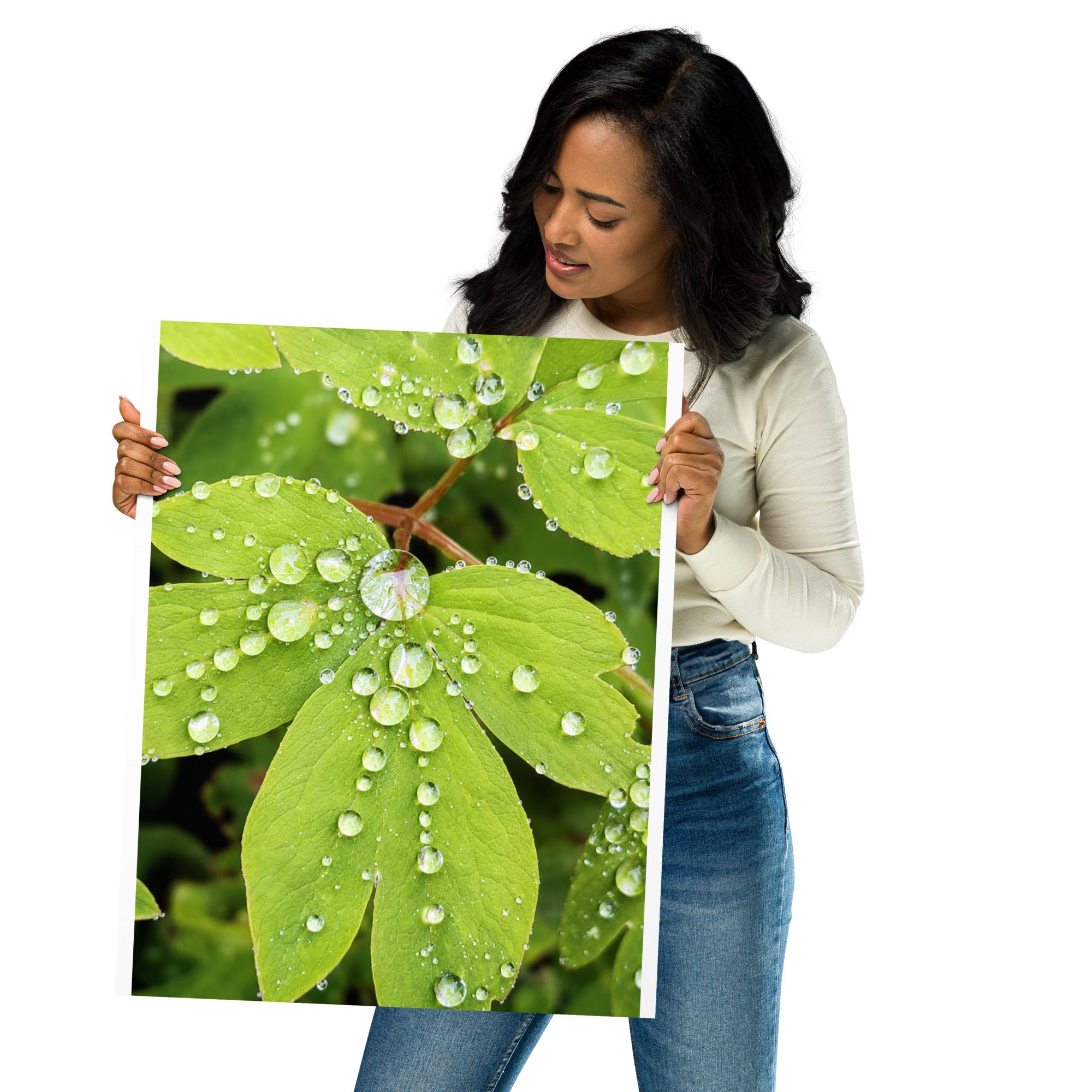 Woman holding the "After the Rain" poster featuring water droplets on bright green leaves.